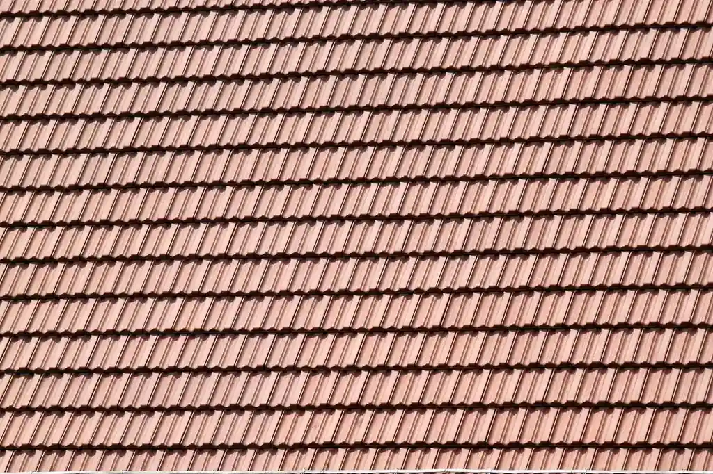 Professional roofer inspecting roof shingles for damage