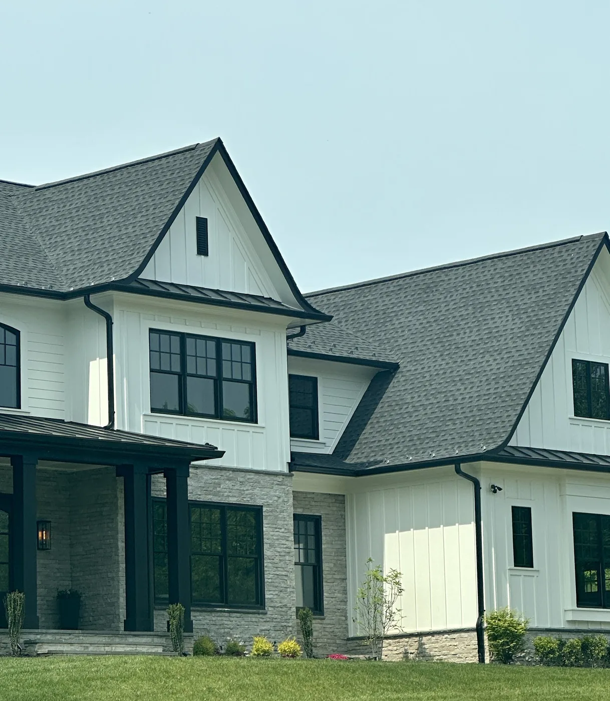 Architectural shingle roof with standing seam metal porch roofs